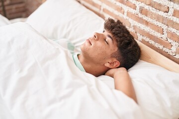 Fototapeta na wymiar Young hispanic teenager lying on bed sleeping at bedroom