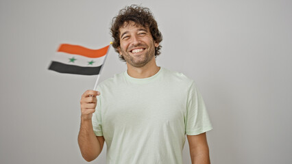 Young hispanic man smiling confident holding syria flag over isolated white background