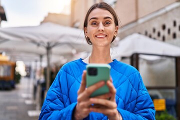 Young caucasian woman smiling confident using smartphone at coffee shop terrace