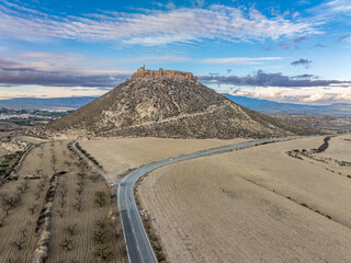 Aerial view of Castillo de Alcalá or Castillo de La Puebla, Arab castle in Murcia province Spain on top of a flat-top limestone mountain. Large rectangular tower, angled entrance, deep well and cister