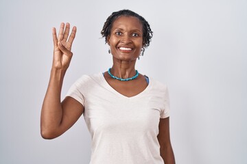 African woman with dreadlocks standing over white background showing and pointing up with fingers number four while smiling confident and happy.