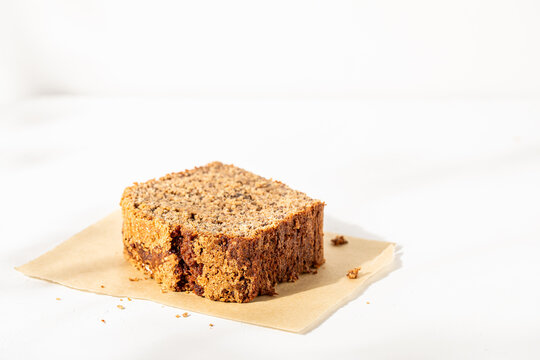 Slice of banana bread on white plaster surface
