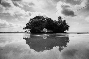 A small house on an island reflected in the ocean, Sri Lanka