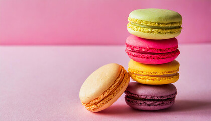 Fototapeta na wymiar Macaroons stacked on pink background, copyspace on a side