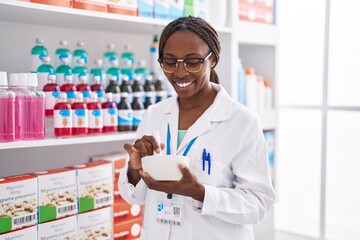 African american woman pharmacist smiling confident make mixture at pharmacy