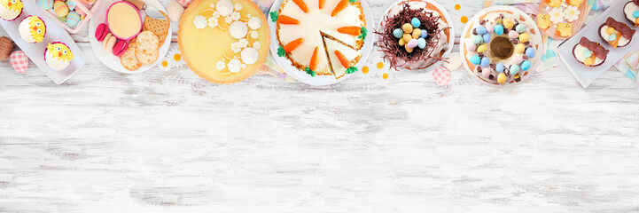 Obraz na płótnie Canvas Easter or spring dessert food top border. Above view over a white wood banner background. Lemon tart, cupcakes, Easter egg and carrot cakes and a variety of sweets. Copy space.