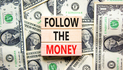 Follow the money symbol. Concept words Follow the money on beautiful wooden blocks. Dollar bills....