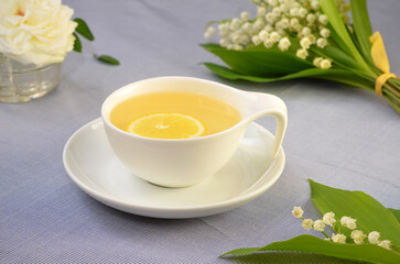 still life in light colors, a cup of tea and white flowers on the table
