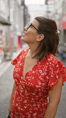 Joyful hispanic woman flashing a winning smile on osaka streets