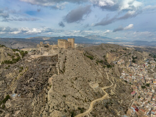 Aerial panorama view of Castillo de los Velez, medieval ruined castle perched on top of Mula, keep, well tower, machicolation, Parroquia Mayor De Santo Domingo De Guzmán church, 