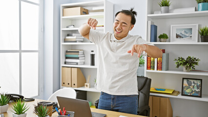 Positive asian man dancing to music while confidently working at his office, the joy of a young, handsome chinese business worker successfully managing tasks online on laptop.