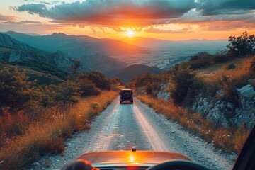 As the sun sets behind the towering mountains, a car traverses the winding dirt road, surrounded by the tranquil beauty of nature and the promise of adventure - obrazy, fototapety, plakaty