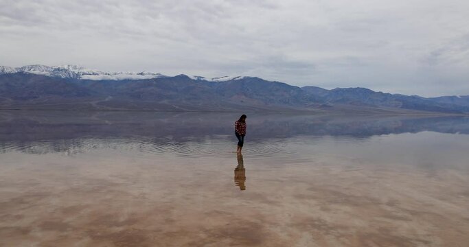 Death Valley Badwater Basin lowest in USA woman walking water. Largest national park in contiguous USA. 282 feet below sea level. Mojave Desert bordering Great Basin Desert. Ecological geology. 