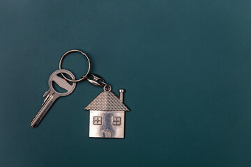 estate concept, keychain with house symbol, key on blackboard background
