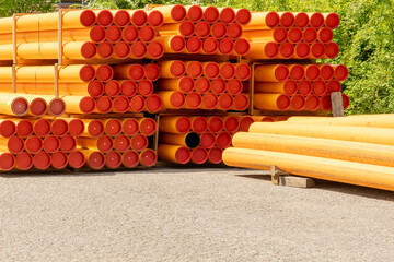 Orange line pipes laid in stock on a construction site
