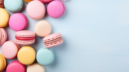Fototapeta na wymiar Colorful macarons on pastel background with copy space, top view and flat lay composition