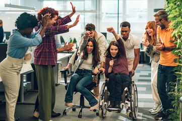 Portrait of a diverse inclusive people having fun and racing on office chairs