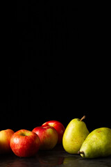 Group of apples and pear isolated on a dark background