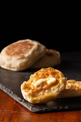 Buttered toasted English muffin dark background