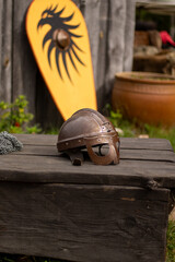 A viking helmet in front of a viking shield.