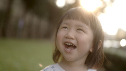Asian girl laughing happily in a park