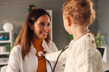 Little boy patient using stethoscope by himself and playing with the doctor