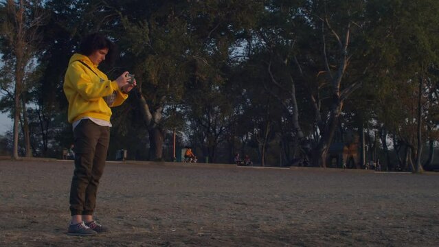 Girl taking photos of a late at sunset