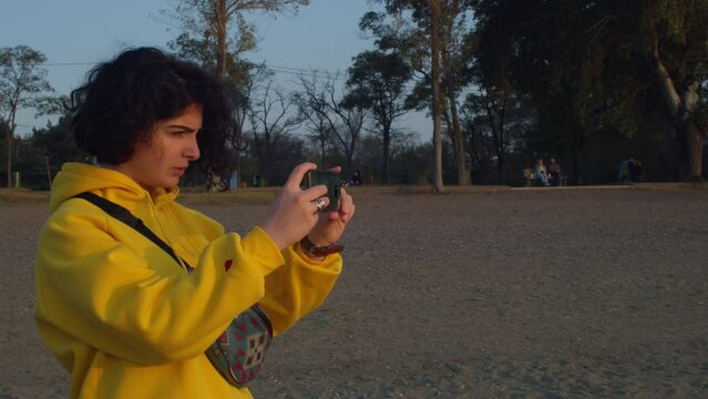 Girl taking photos of a late at sunset