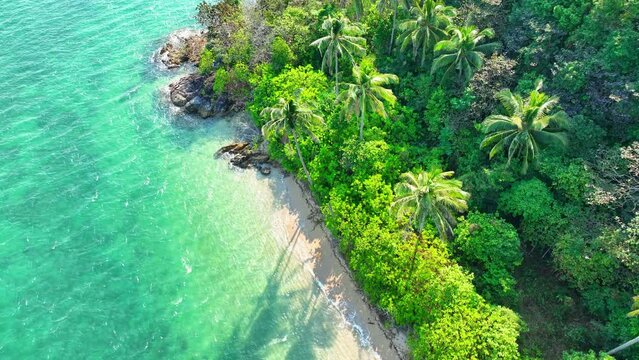 Aerial view of a pristine tropical island, crystal-clear waters, sun-kissed sandy beach, and swaying coconut palms. Landmarks and nature concept. Stock footage. Ko Chang, Thailand. 4K.
