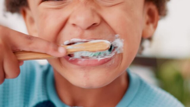 Boy child, brushing teeth and closeup in bathroom, bamboo toothbrush and sustainability in family home. Kid, toothpaste and foam for cleaning, wellness and health with dental care in morning at house