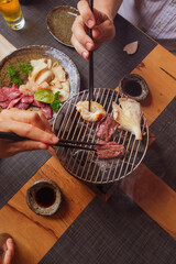 People sharing a japanese yakiniku barbecue on the grill