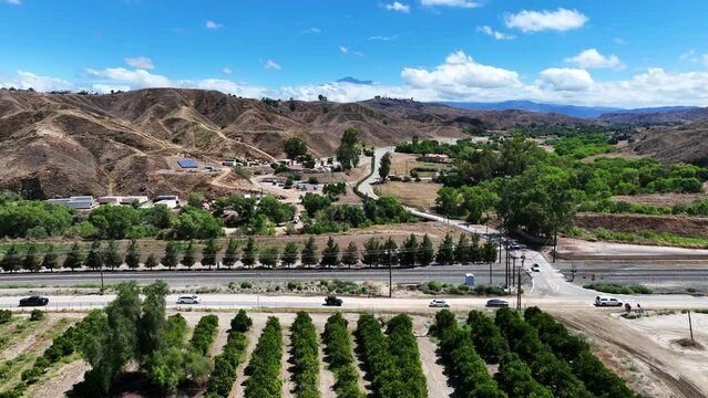 San Timoteo Canyon at the Train Rail Crossing with cars using the road near an Orange Grove in Redlands California