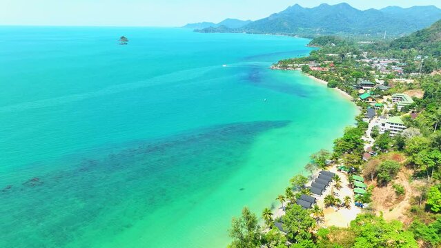 Nature's masterpiece from above, Idyllic tropical coast, turquoise sea, resorts by the shore, lush mountain greenery, and a vast blue sky paint a stunning picture. Ko Chang, Trat Province, Thailand.
