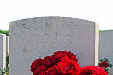 Anonymous grave of an unknown soldier of the great war with fresh red flowers in Flanders Fields, Ypres, Flanders, Belgium