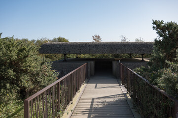 Fototapeta premium Detail of the entrance gate of a large German bunker in Longues Sur Mer, hidden among the vegetation