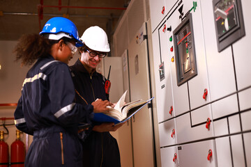 Male and Female electrical engineer working in electrical control room, Main Distribution Board