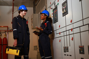 Male and Female electrical engineer working in electrical control room, Main Distribution Board