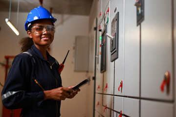 portrait smaile Female electrical engineer work at front of MDB main distribution board room,...