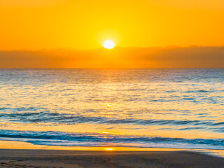 Pretty blue sunrise at the beach with calm seas