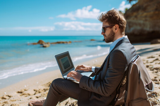 A businessman working on a laptop at the beach depicting working remotely or being a digital nomad