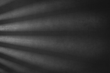 Mur de couleur noir avec effet de lumière du jour pour création de fond et arrière plan. Ombre avec lumière à travers un store de fenêtre.