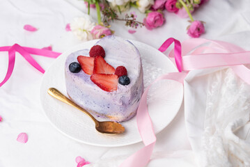 Trendy bento cake in love heart shape form on a light breakfast in bed background. Cake for Valentine's Day, Mother's Day, or Birthday, Love Forever Message, Romantic Bento Cake for Two