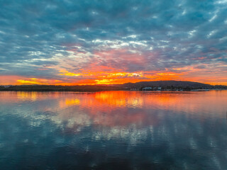 Sunrise over the bay water with clouds and reflections