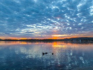 Fototapeta premium Sunrise over the bay water with clouds and reflections