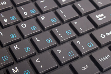 Black keyboard with background close up. Black button with illuminated characters.