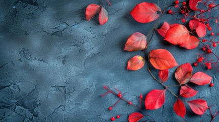Red leaves and berries beautifully arranged on a gray surface. Perfect for autumn-themed designs and nature-inspired projects