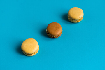 Colorful cake macaron or macaroon on blue background. Flat lay, top view, copy space