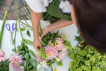 Florist Crafting a Pink Dahlia Bouquet. Florist at work. Workplace. Small business. Background.