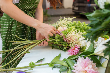 Florist's Hands Finishing a Floral Bouquet. Florist at work. Workplace. Small business. Background.