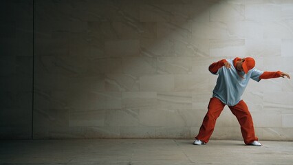Handsome choreographer practice street dance in gray background. Young attractive b boy dancer...